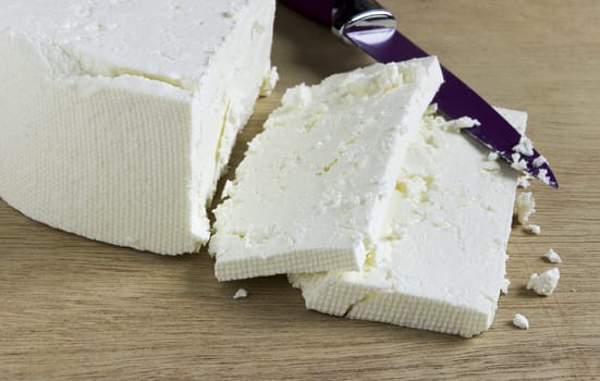 White cottage cheese on a wooden board, sliced