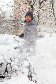 Man shoveling her parking lot after a winter snowstorm.