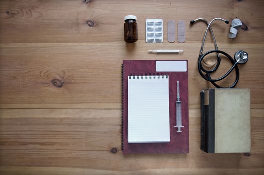 Medical objects laid out on a wooden table with space