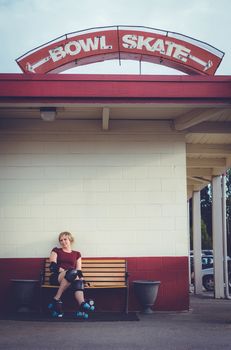 Woman on roller skates outside of a roller rink.