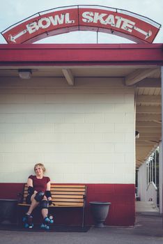 Woman on roller skates outside of a roller rink.