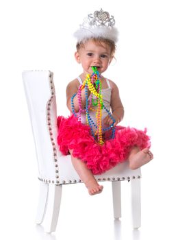 happy one year old girl wearing tutu standing on a white chair