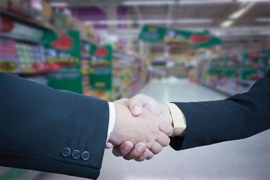 Business handshake with blur background of shopping mall