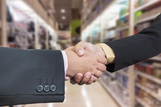 Business handshake with blur background of shopping mall