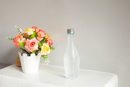 flower and bottle of water, on white table