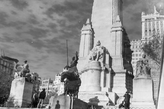 Reflection in water of stone statue of Miguel de Cervantes and bronze sculptures of Don Quixote and Sancho Panza on the Square of Spain, Plaza de Espana, in Madrid. Black and white image.