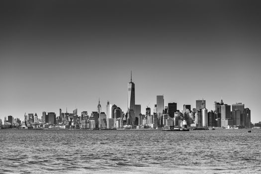New York City Manhattan downtown skyline at dusk with skyscrapers illuminated over Hudson River panorama. Horizontal composition, copy space. Black and white image.