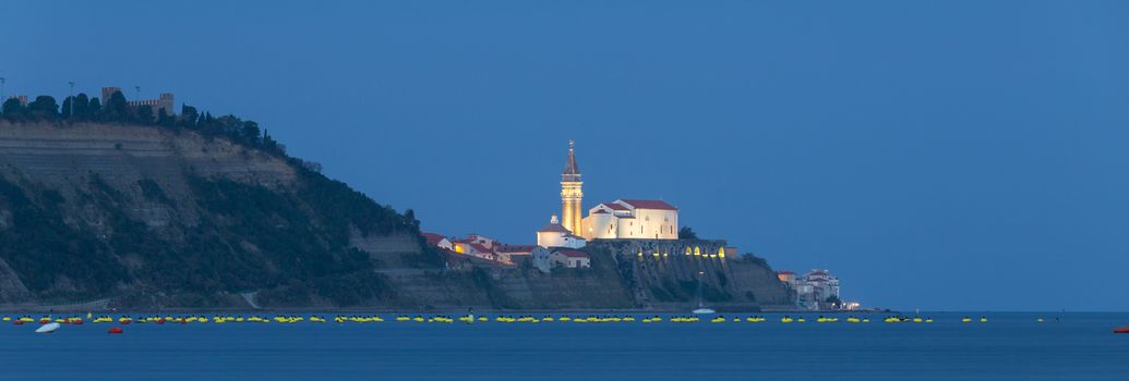 Romantic picturesque old town Piran at dusk, Slovenia. Senic panoramic view. Panoramic composition.