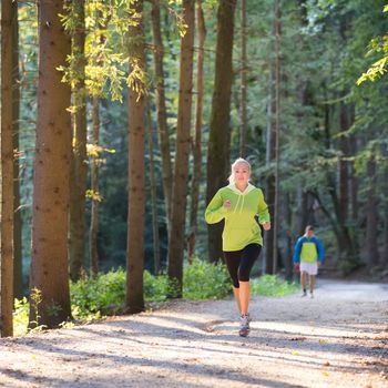 Pretty young girl runner in the forest.  Running woman. Female Runner Jogging during Outdoor Workout in a Nature. Beautiful fit Girl. Fitness model outdoors. Weight Loss. Healthy lifestyle. 