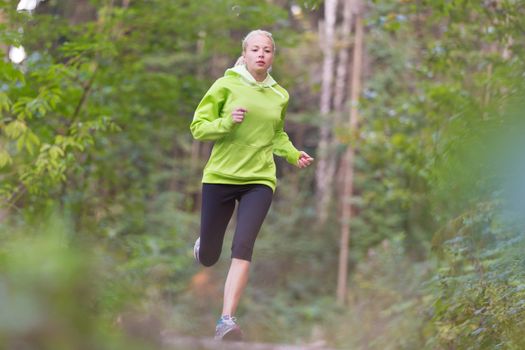 Pretty young girl runner in the forest.  Running woman. Female Runner Jogging during Outdoor Workout in a Nature. Beautiful fit Girl. Fitness model outdoors. Weight Loss. Healthy lifestyle. 