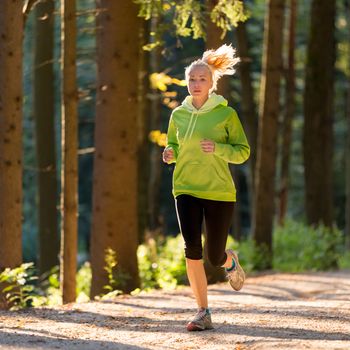 Pretty young girl runner in the forest.  Running woman. Female Runner Jogging during Outdoor Workout in a Nature. Beautiful fit Girl. Fitness model outdoors. Weight Loss. Healthy lifestyle. 