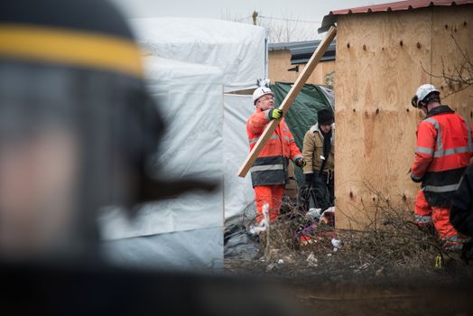 FRANCE, Calais: Demolition workers destroy a hut as they clear part of the jungle migrant camp on March 01, 2016 in Calais, France. Police and demolition teams are continuing to dismantle makeshift shelters in the migrant camp known as the Jungle and relocating many people to purpose-built accommodation nearby. 