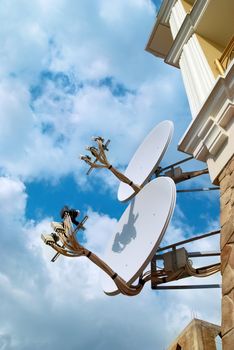 Satellite antenna on the wall with blue sky