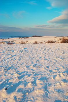 Winter hills covered by snow against sunset