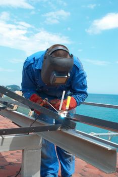 Welder at the factory working with metal construction