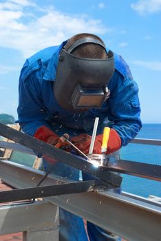 Welder at the factory working with metal construction