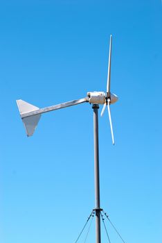 Wind electric turbine generator at blue sky background