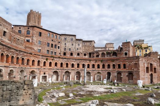 ROME, ITALY - SEPTEMBER 26, 2016 : View of an ancient Roman Forum with columns and ruins around in Rome, with tourists around, on cloudy sky background.
