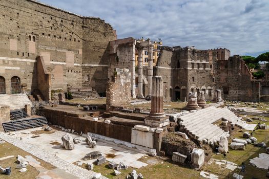 ROME, ITALY - SEPTEMBER 26, 2016 : View of an ancient Roman Forum with columns and ruins around in Rome, with tourists around, on cloudy sky background.