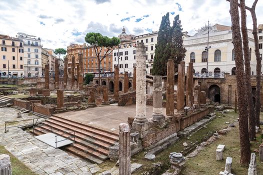 ROME, ITALY - SEPTEMBER 26, 2016 : View of an ancient Roman Forum with columns and ruins around in Rome, with tourists around, on cloudy sky background.