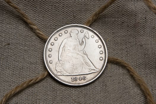 Old silver dollar of the USA over sack with rope