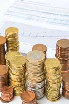 Stack of coins and business chart on background