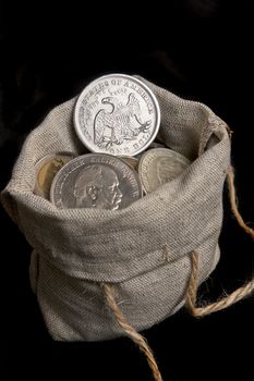 USA old silver dollar in sack bag isolated on black