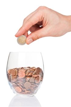 Hand with 2 euro coin  and glass with euro cents isolated on white