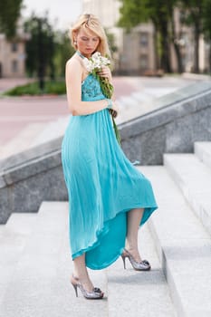 Blond Girl on stairs with flower on hand look down