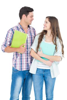 Portrait of students couple holding books on white background 