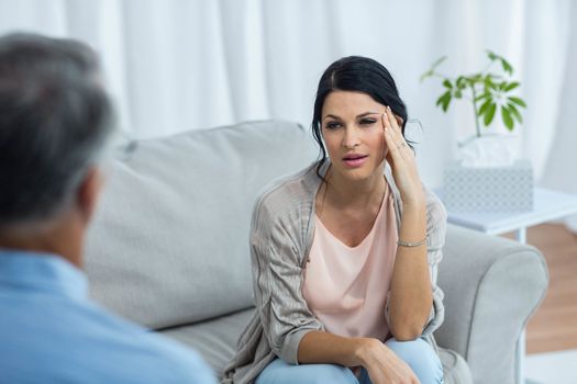 Therapist talking to worried woman at home