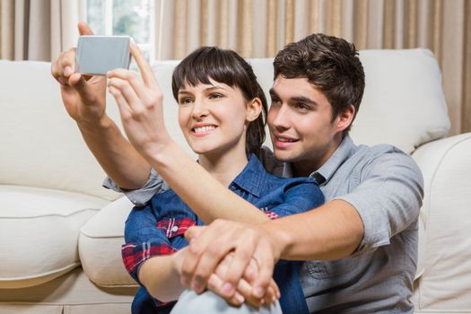Romantic couple taking selfie in their living room