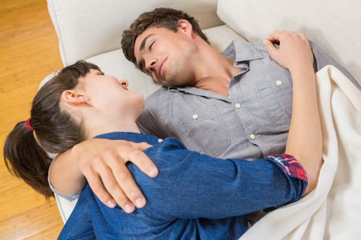 Romantic couple at home relaxing on the sofa in their living room