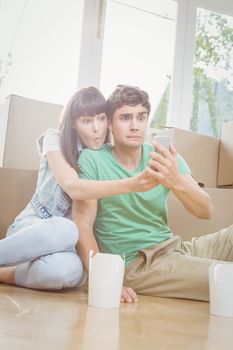 Young couple using mobile phone in their new house