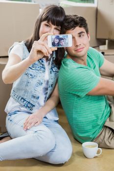 Young couple using mobile phone in their new house