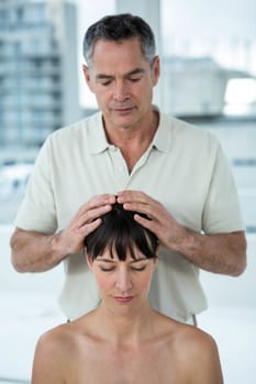 Pregnant woman receiving a head massage from masseur at the health spa