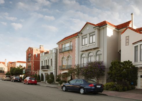 Panoramic view of sunset street, houses and cars