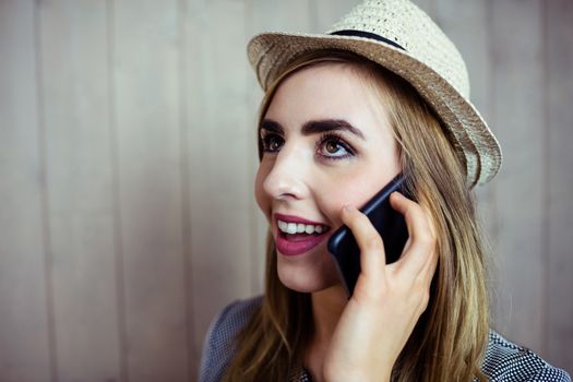 Pretty blonde woman on the phone on wooden background