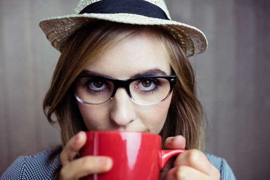 Pretty blonde woman having coffee on wooden background