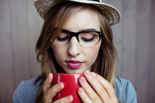 Pretty blonde woman having coffee on wooden background