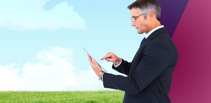 Mid section of a businessman touching tablet against grassy field against sky