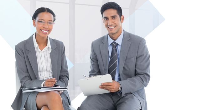 Portrait of smiling business people with paperwork against room with large window looking on city