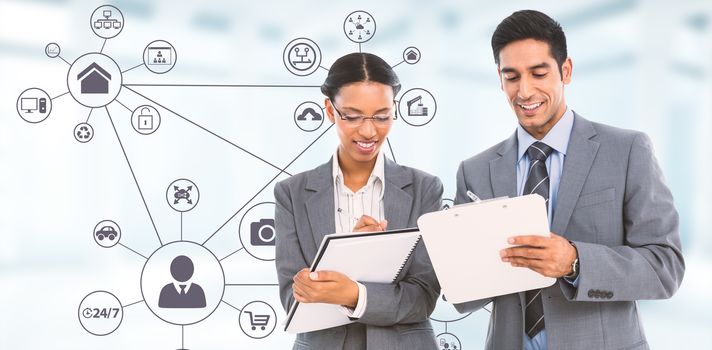 Smiling business people writing on clipboard and notebook against modern room overlooking city