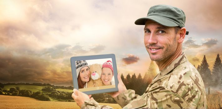 Soldier using tablet pc against country scene