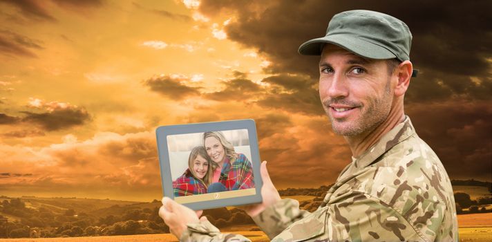 Soldier using tablet pc against country scene