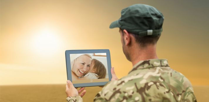 Soldier using tablet pc against desert scene