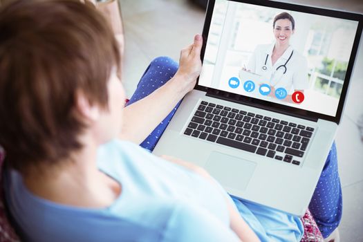 Pregnant woman using her laptop against beautiful doctor reading files