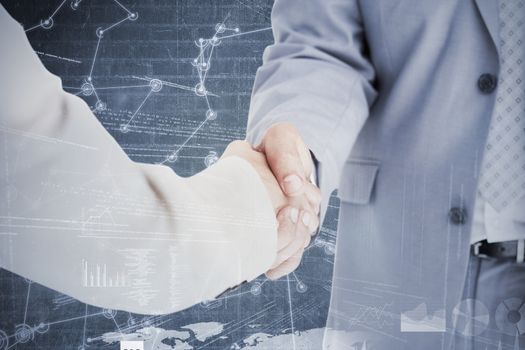 People in suit shaking hands against hologram background