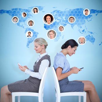 businesswomen sitting back-to-back on the chairs against background with world map