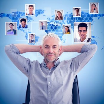 Relaxed mature businessman with hands behind head against background with hexagons and world map